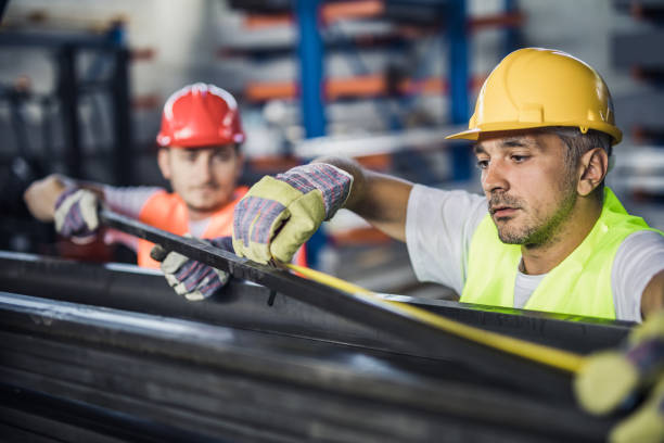 travailleurs de la métallurgie coopérant tout en mesurant l'acier dans l'usine d'aluminium. - aciériste photos et images de collection