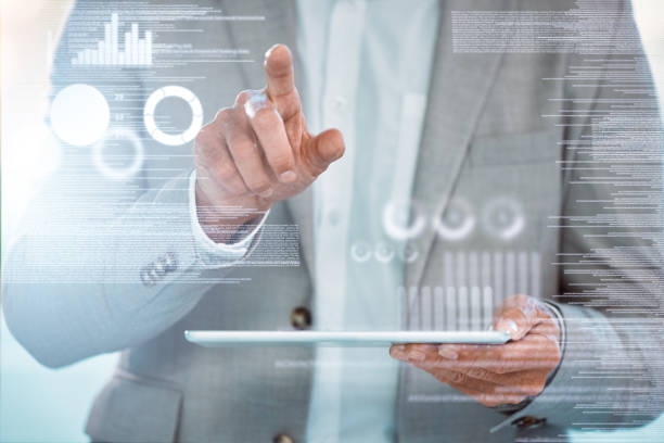 istock Shot of an unrecognizable businessman sitting alone and using a tablet with graphical images in a office 1366545400
