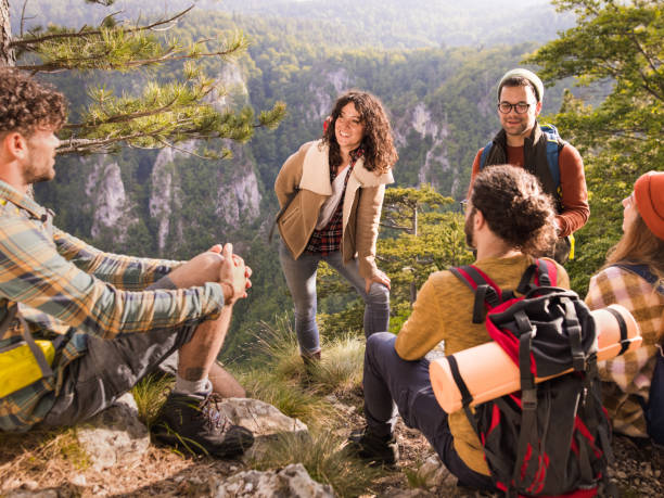 istock Happy backpackers talking on a break at rocky mountain. 1366545517