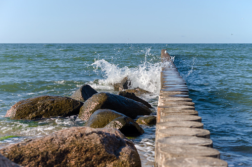 Waves and a storm at sea. Waves crashing on breakwaters. Sea wave splashing. Baltic Sea.