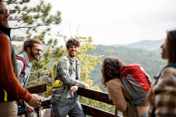 istock Young happy hikers talking on a break at mountain. 1366545867
