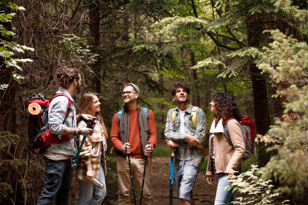 istock Young happy hikers talking on a break in forest. 1366545925