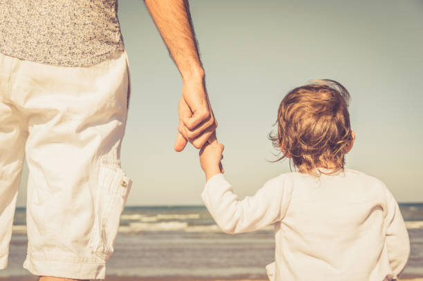 ojciec i córka trzymający się za ręce na plaży. kocham cię tato. koncepcja rodziny - sky human hand water white zdjęcia i obrazy z banku zdjęć