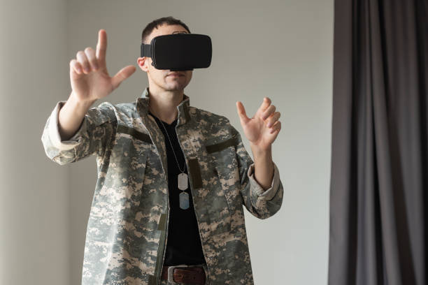 istock Military man trying to touch virtual objects while wearing a VR headset. Disability and modern gadgets. 1366549966