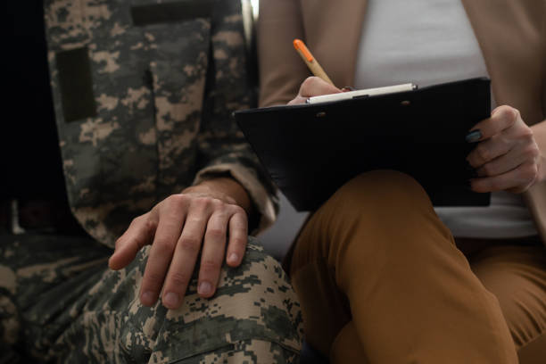 istock Young psychotherapist taking notes while listening young veteran who talking about his problems. 1366552470