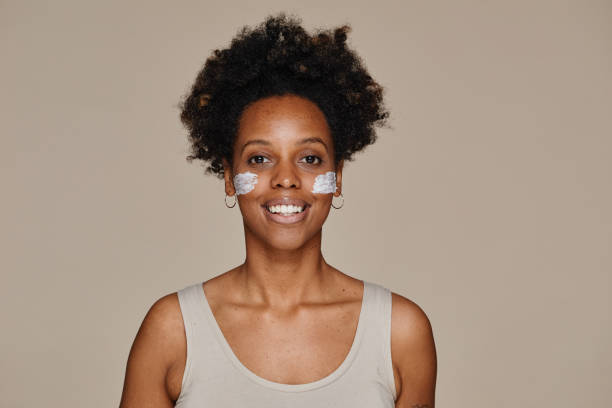 istock Smiling Black Woman with Face Cream Minimal 1366553617