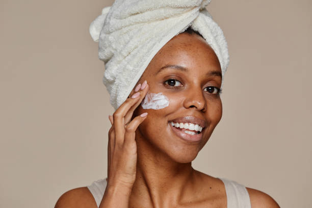 istock Smiling Black Woman Applying Face Cream 1366553720
