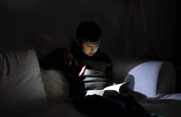 Photo of Reading A Book With Flashlight During Power Outage