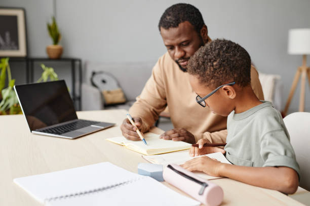 istock Boy Studying with Father at Home 1366555023