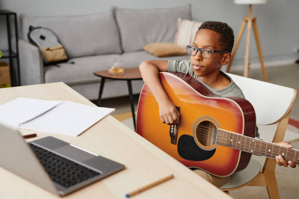 istock African American Boy in Guitar Lesson Online 1366555037
