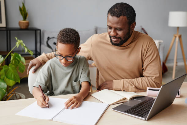 istock Father and Son Studying at Home Together 1366555120