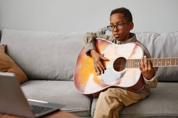 istock Boy in Guitar Lesson Online 1366555128
