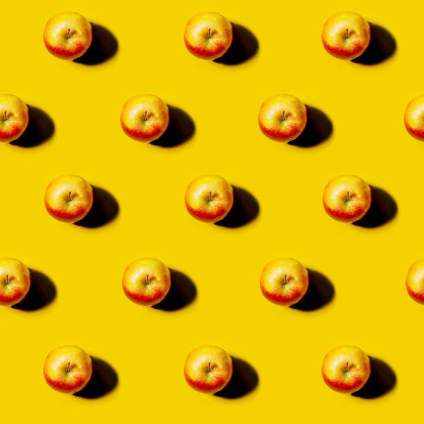 istock red Apple pattern on bright yellow background. Minimal flat lay food texture. Summer abstract trendy fresh concept. 1366555815