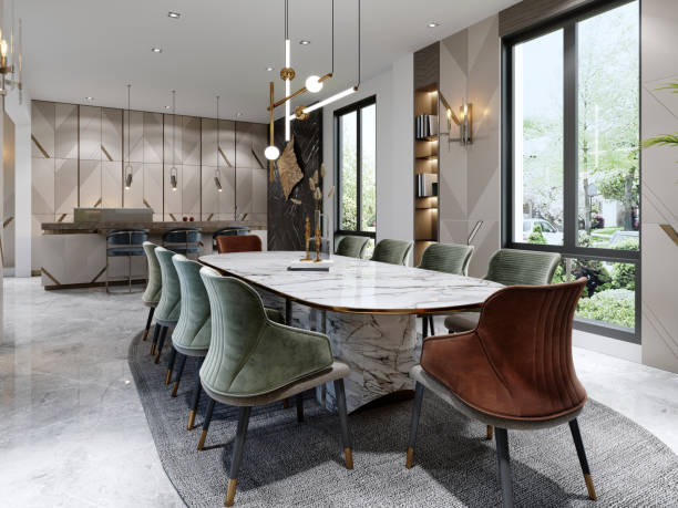 istock Dining room and table with white marble with red and green chairs and beige kitchen with trendy furniture with lamps. 1366557558