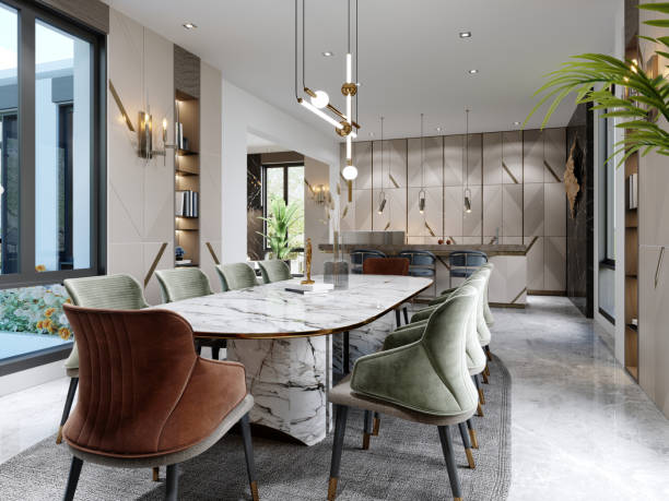 istock Dining room and table with white marble with red and green chairs and beige kitchen with trendy furniture with lamps. 1366557590