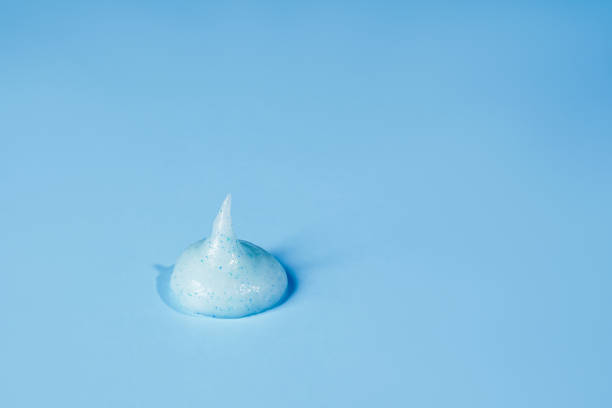 istock Cream scrub smear smudge stroke isolated on blue background. Cosmetic exfoliating scrub texture. Blue skincare mask sample cut out 1366559925