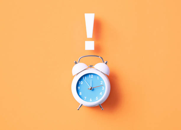 istock Exclamation Point Sitting Above White Alarm Clock On Orange Background 1366560126
