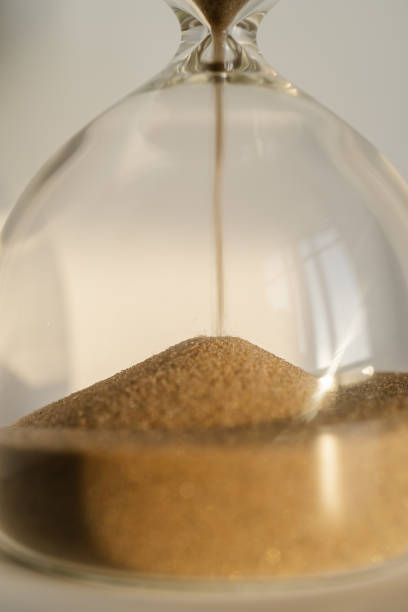 istock Transparent hourglass on a white sunny background. 1366561555