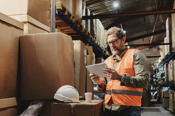 istock Warehouse workers checking packages in distribution center storage. 1366562369