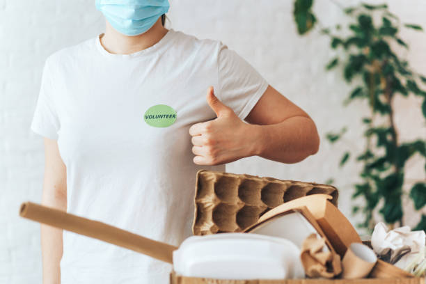 istock Girl standing next to box filled with garbage shows like 1366564045