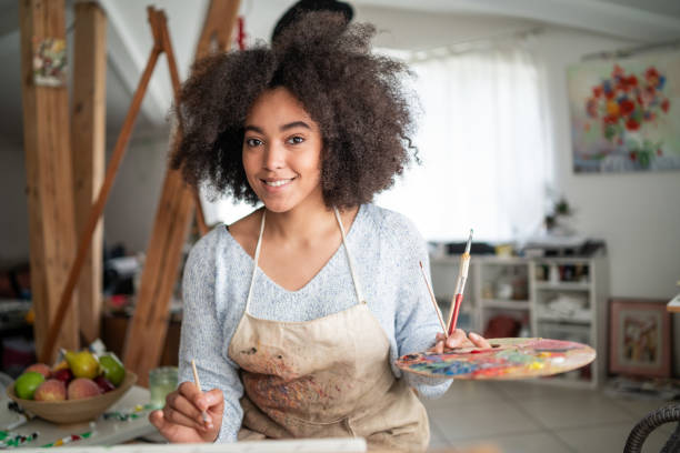 istock Afro female fine artist  drawing in studio 1366564448