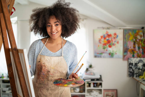 istock Afro female fine artist  drawing in studio on a canvas, placed on a tripod 1366564453