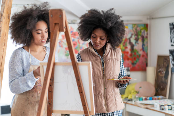 istock Afro female fine artists drawing together  in an art studio 1366564587