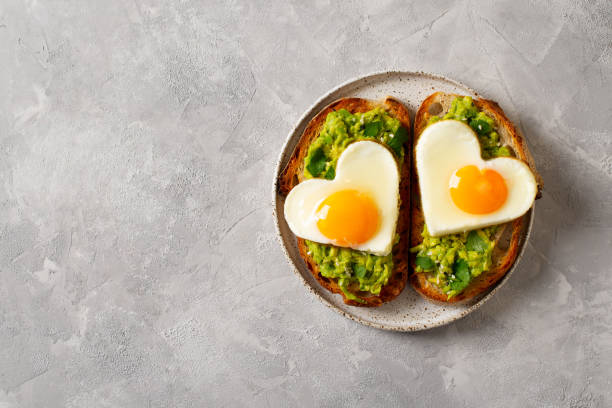 istock Healthy breakfast with eggs hearts and cup of coffee on grey background 1366564983