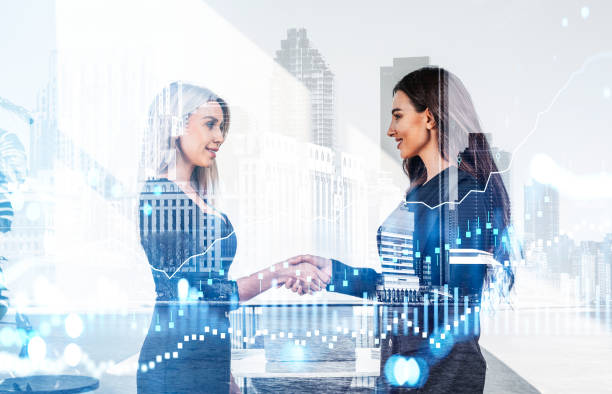 istock Two businesswomen wearing formal suits work together shaking han 1366566006