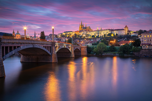 Cityscape image of Prague, capital city of Czech Republic with St. Vitus Cathedral and the Charles Bridge over Vltava River at sunset.