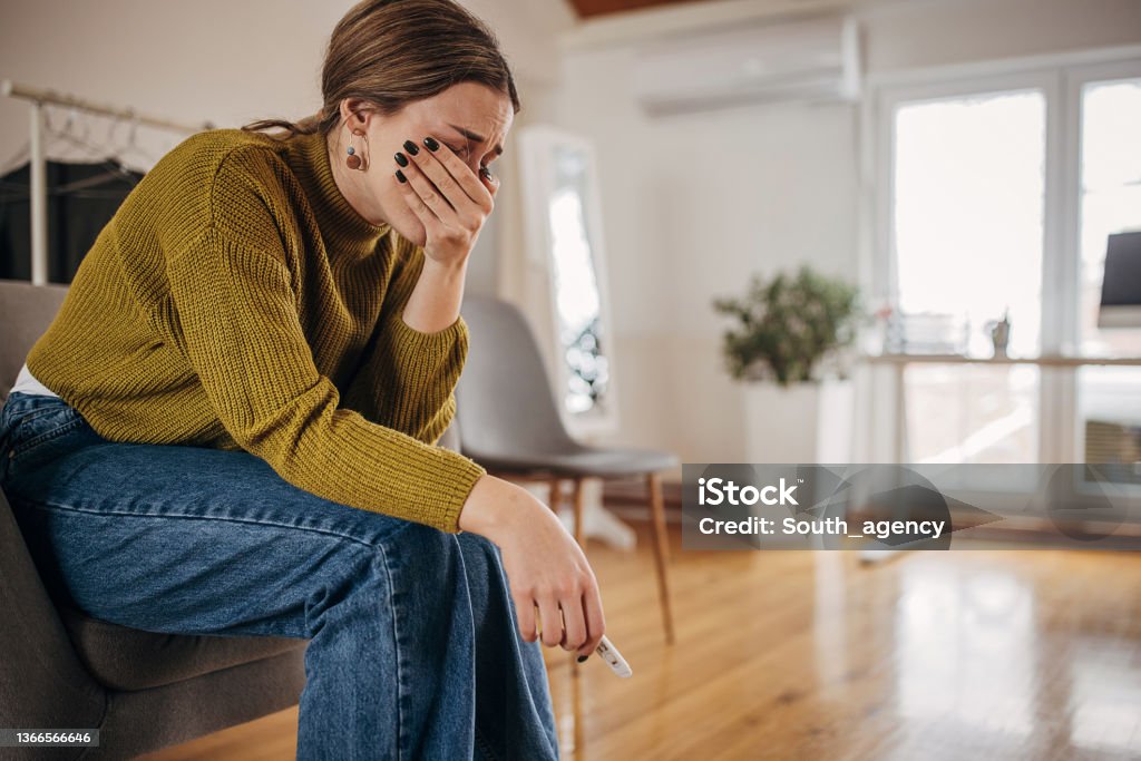 Disappointed woman crying because pregnancy test is negative again Sad woman crying because pregnancy test is negative again Miscarriage Stock Photo