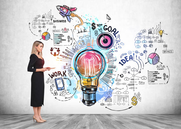 istock Woman with tablet near business strategy plan and lightbulb on grey wall 1366567214