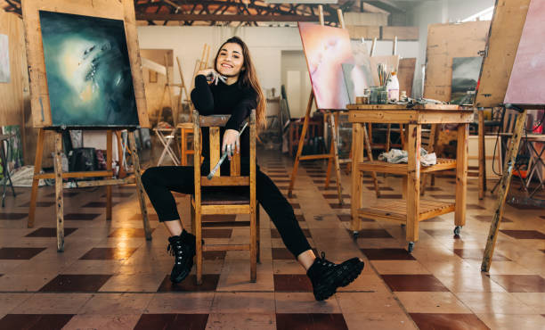 istock Happy female painter smiling at the camera in her workshop 1366571942