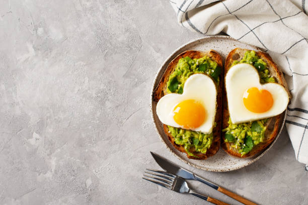 Healthy breakfast with eggs hearts and cup of coffee on grey background