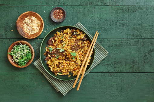 Thai Beef Fried Rice. Flat lay top-down composition on dark green background.