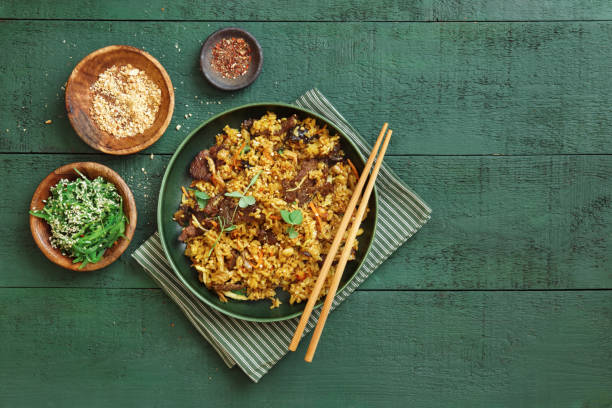 Thai Beef Fried Rice Thai Beef Fried Rice. Flat lay top-down composition on dark green background. fried rice stock pictures, royalty-free photos & images