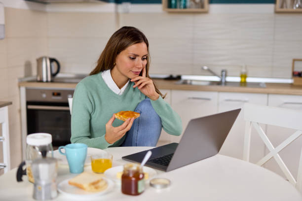 istock Young woman making a video call on her laptop during breakfast 1366574572