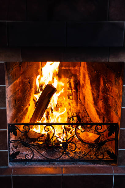 istock Burning fireplace, close up.  Cozy atmosphere autumn or winter evening. Open fire with real flames, firewood burning in fireplace. 1366575274