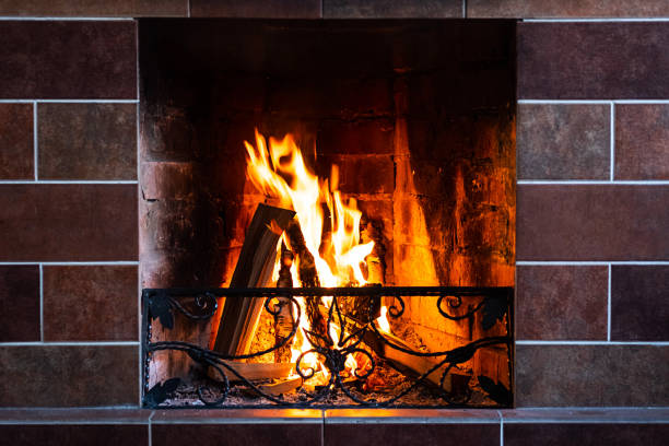 Burning fireplace, close up.  Cozy atmosphere autumn or winter evening. Open fire with real flames, firewood burning in fireplace.
