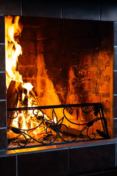 istock Burning fireplace, close up.  Cozy atmosphere autumn or winter evening. Open fire with real flames, firewood burning in fireplace. 1366575276