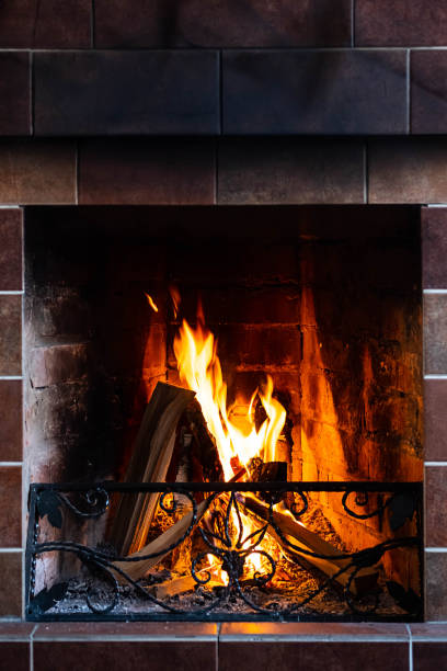 istock Burning fireplace, close up.  Cozy atmosphere autumn or winter evening. Open fire with real flames, firewood burning in fireplace. 1366575279
