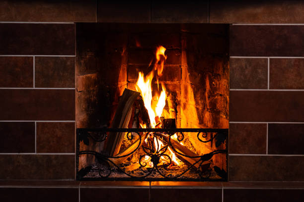 istock Burning fireplace, close up.  Cozy atmosphere autumn or winter evening. Open fire with real flames, firewood burning in fireplace. 1366575280
