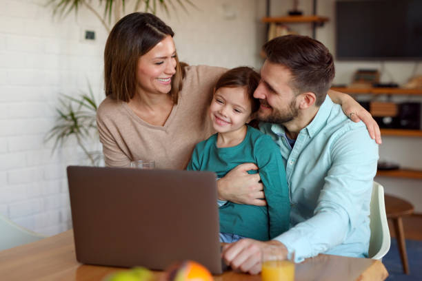 istock Happy family using laptop and making video call at home 1366575304