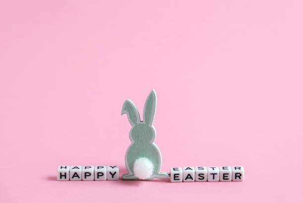 istock Cubes with letters and Easter bunny decor. Happy Easter inscription on  pink background. Festive card for Easter. 1366575356