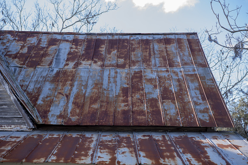 Rustic wood building detail with rusting metal roof and peeling paint on cladding. Photo taken in Brooker, North Central Florida. Nikon D750 with Nikon 24-70mm ED VR lens