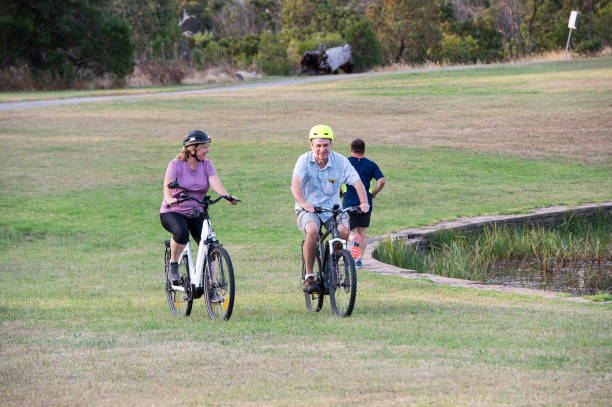 istock People riding Electric Bikes and Running through Park 1366576689