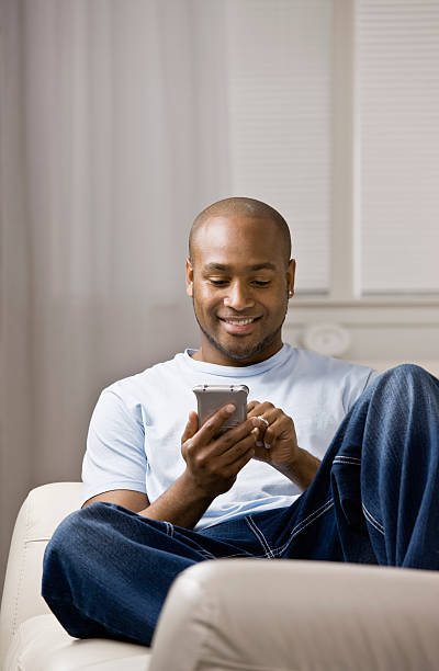 istock Man lounging on a couch with his cellular phone 136657861