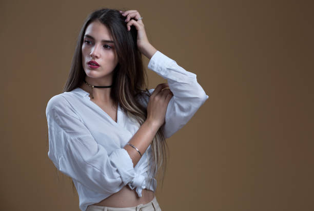 istock A girl in a white blouse on a beige background 1366579252