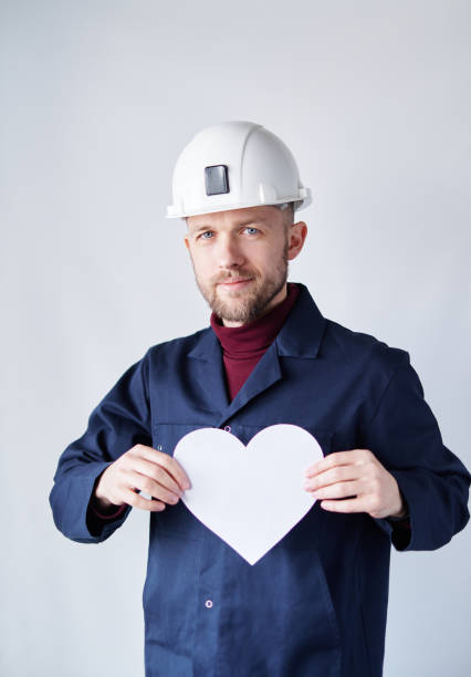 istock Valentine's Day concept: worker in helmet with paper heart 1366580411