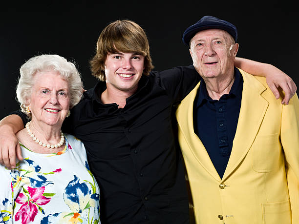 Teenage boy posing with his grandparents Teenage boy posing with his grandparents on black background (this picture has been taken with a Hasselblad H3D II 31 megapixels camera) grandmother real people front view head and shoulders stock pictures, royalty-free photos & images